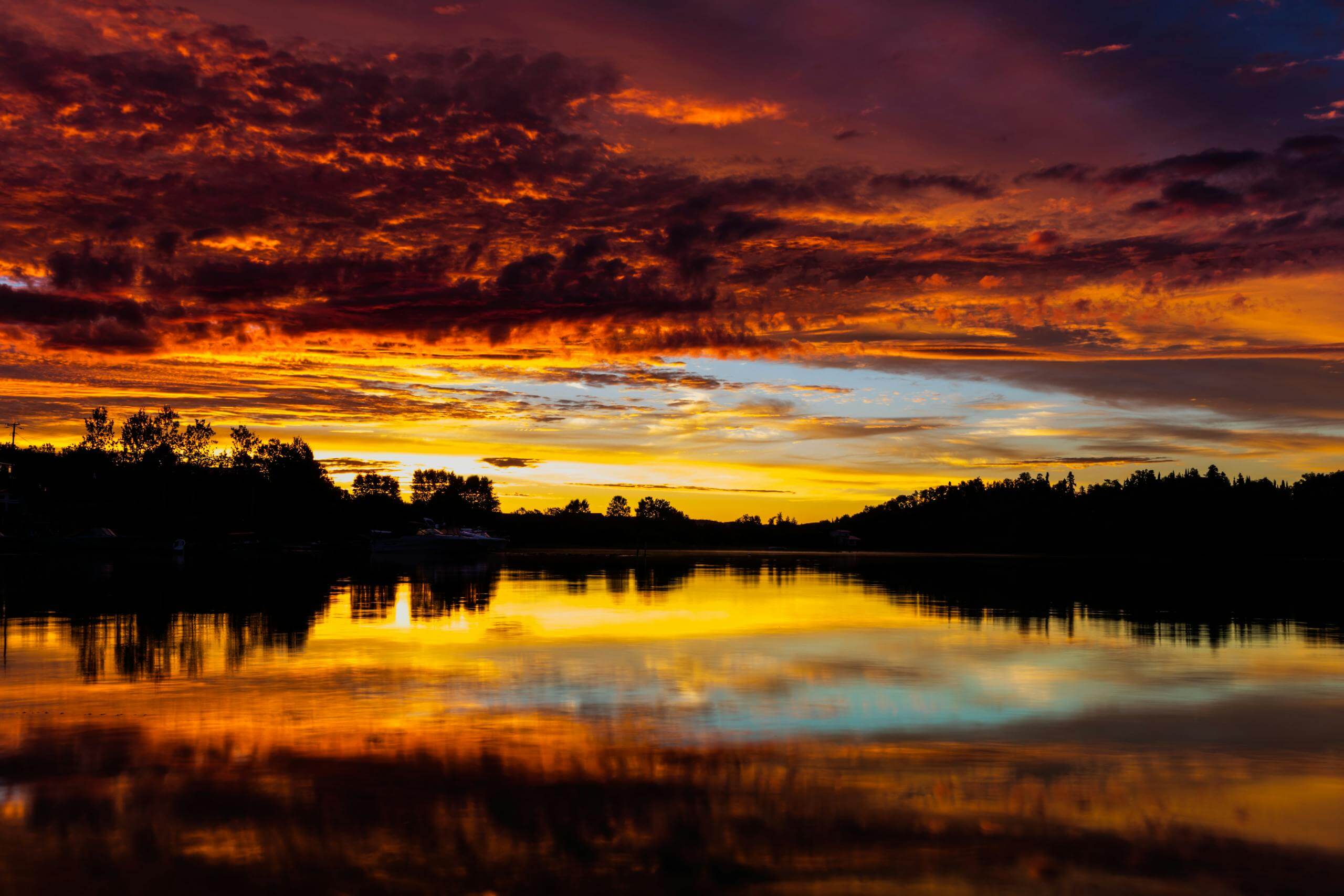 Breathtaking sunset over calm lake with vivid reflections in a colorful sky.